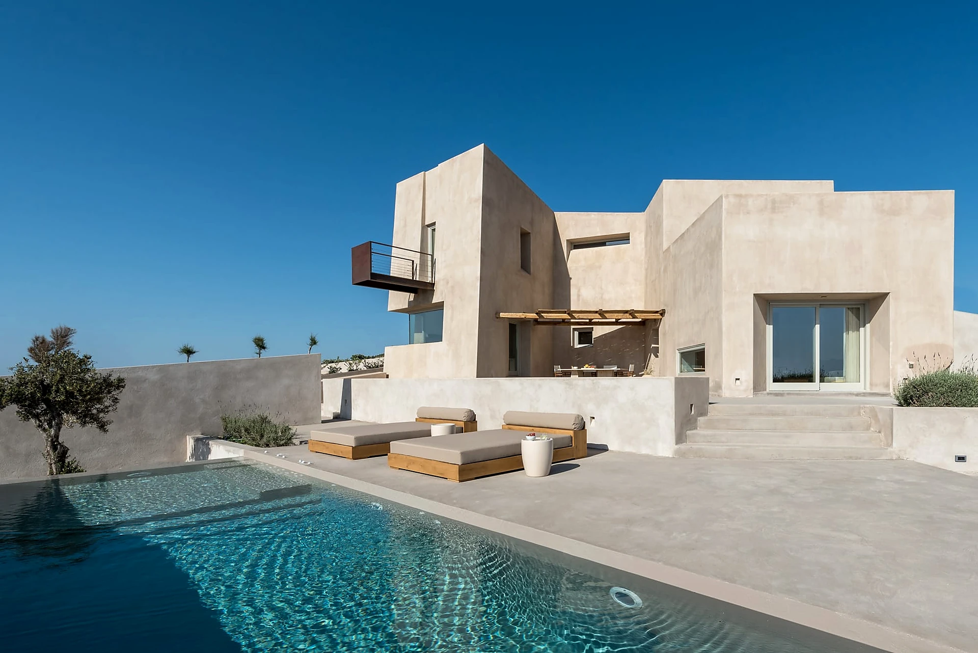 Contemporary concrete residence with geometric volumes beside an outdoor pool