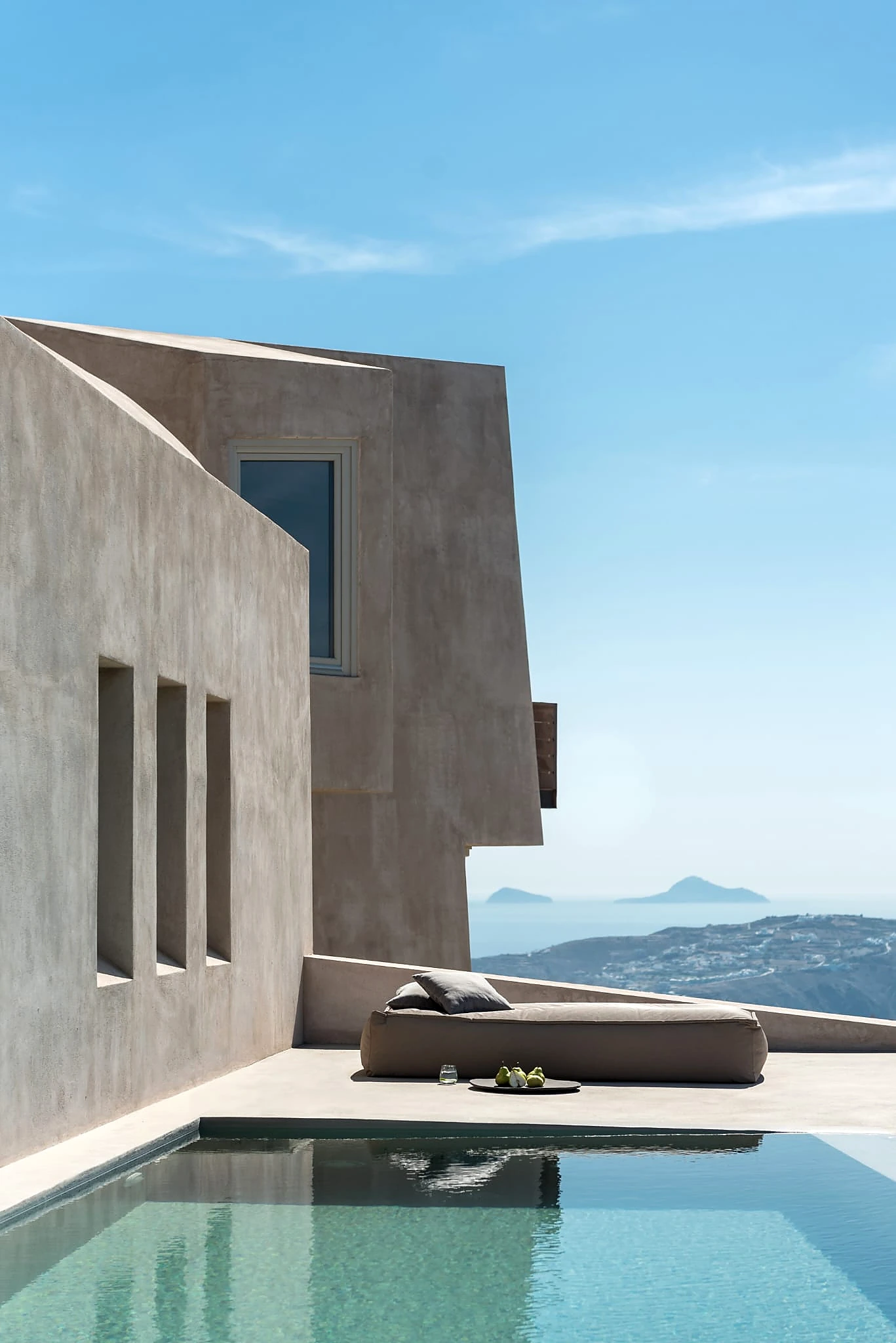 Angular concrete architecture overlooking a swimming pool and the sea