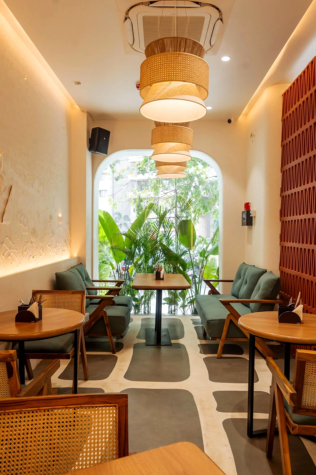 Restaurant passage with curved pendant lights, dining tables and patterned flooring
