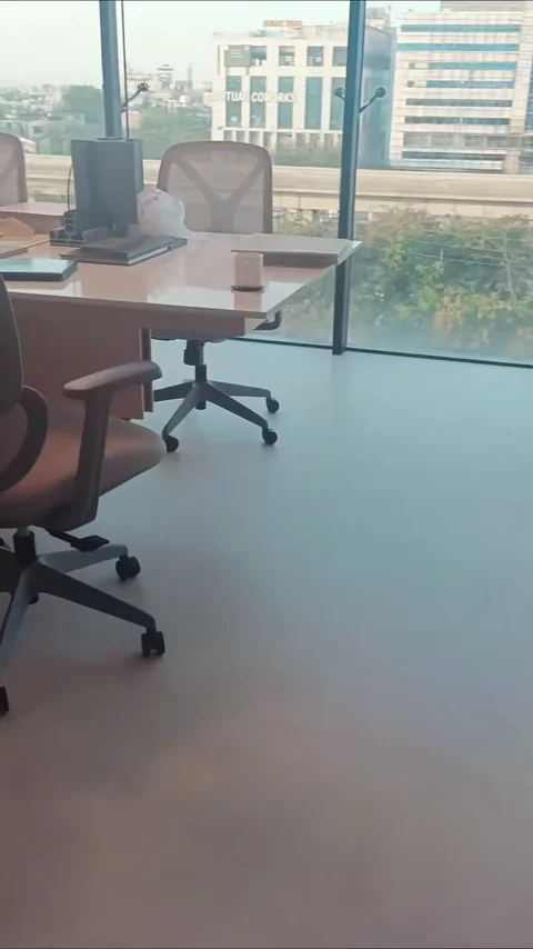 AXA architects, Indore — office with glass partitions and desks beside tall windows