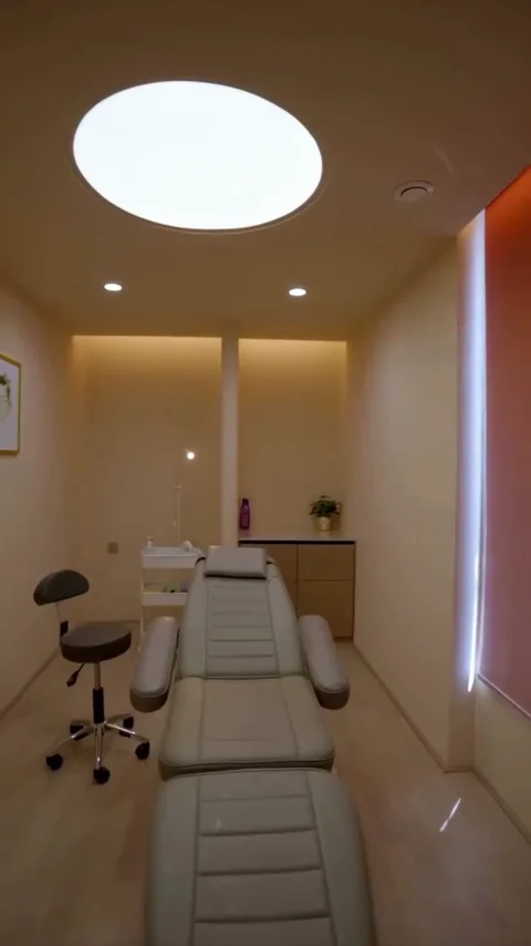 Skin clinic, Chennai — treatment room with curved ceiling lighting and fitted cabinetry