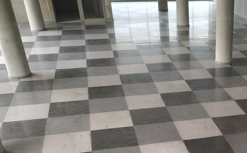 Grey and cream checkerboard terrazzo flooring around concrete columns
